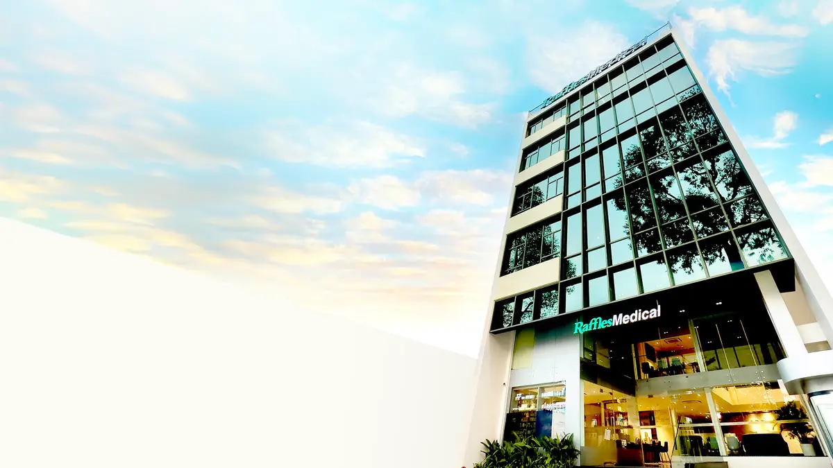 Raffles Medical clinic building with a glass facade and the green Raffles Medical sign.