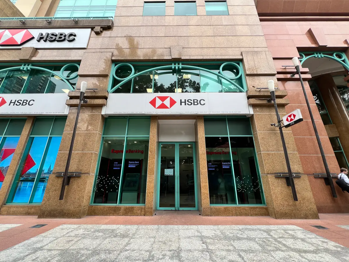 Ground-floor entrance of the HSBC building with red HSBC signs above glass doors.