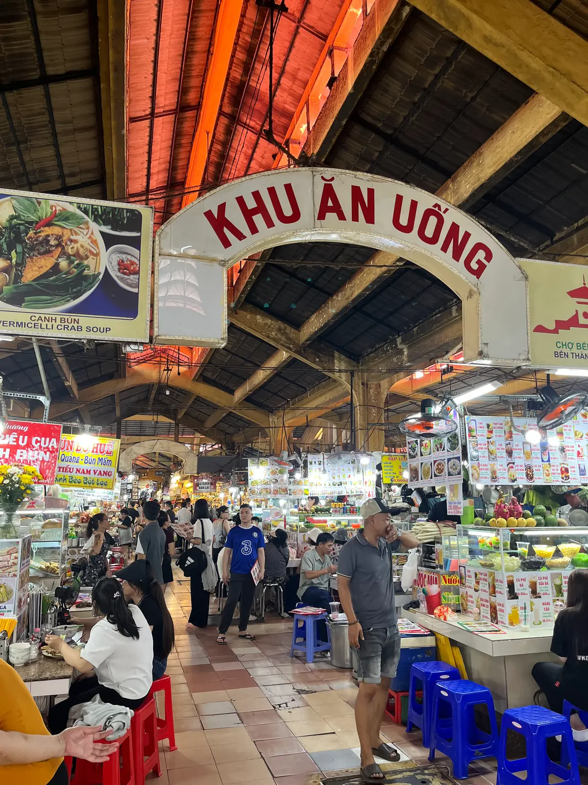Market hall archway with a sign for the eating area above crowded food stalls