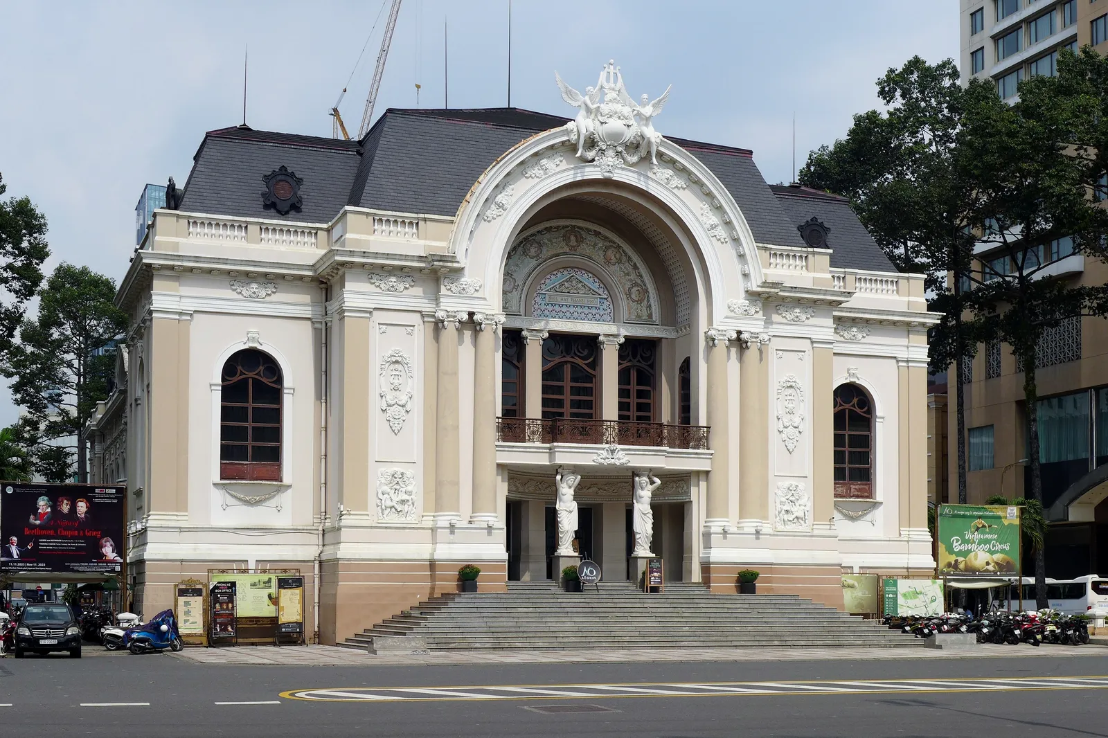 White colonial-style opera house with an arched entrance and steps at a street corner