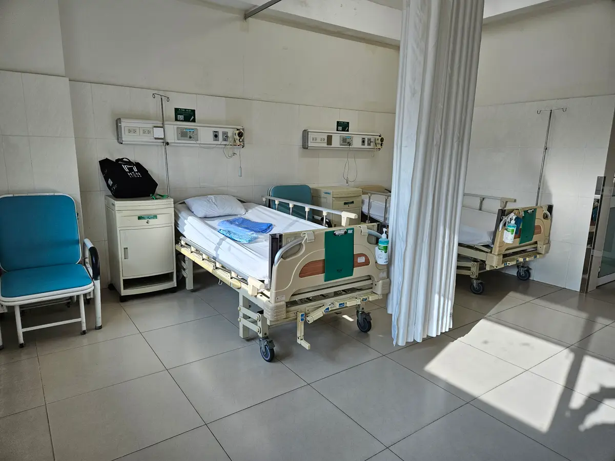 Hospital ward with beds, bedside equipment and a drawn curtain at Hoan My Sai Gon.