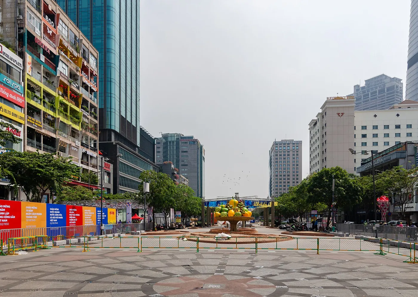 Wide paved pedestrian boulevard lined with colourful apartment buildings and office towers in central Saigon