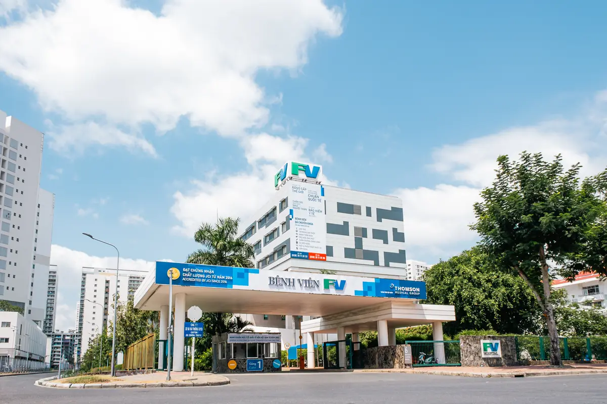 FV Hospital main building behind its covered entrance driveway under a blue sky.