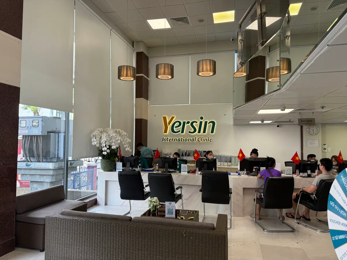 Reception hall at Yersin International Clinic with desks, waiting sofas and the clinic logo on the wall.