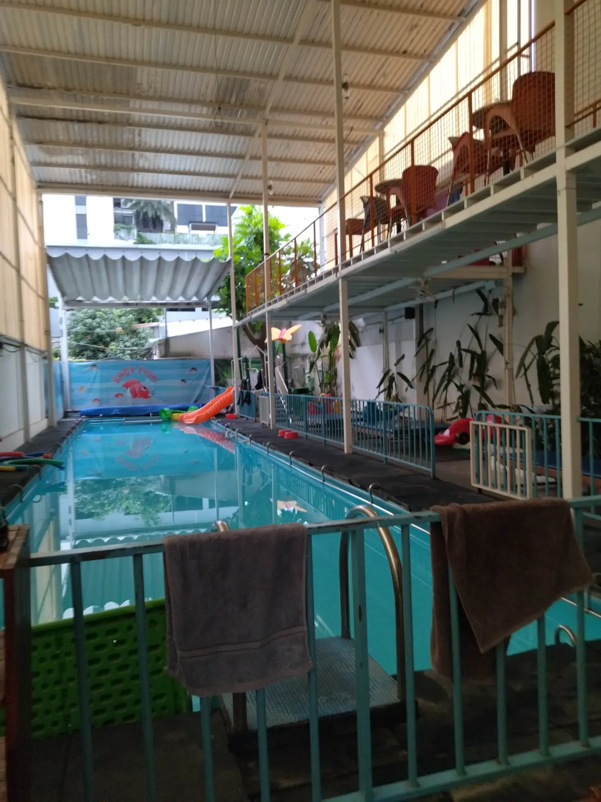 Narrow outdoor pool with a mural on the far wall between two buildings