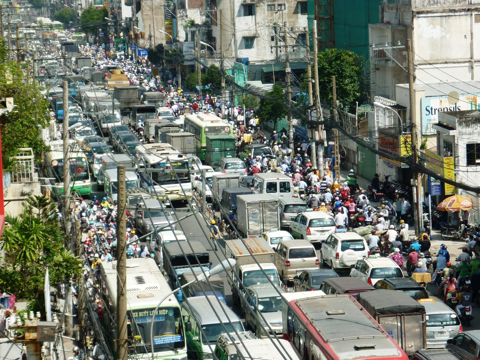 Dense traffic of buses, cars and motorbikes seen from above on a city road