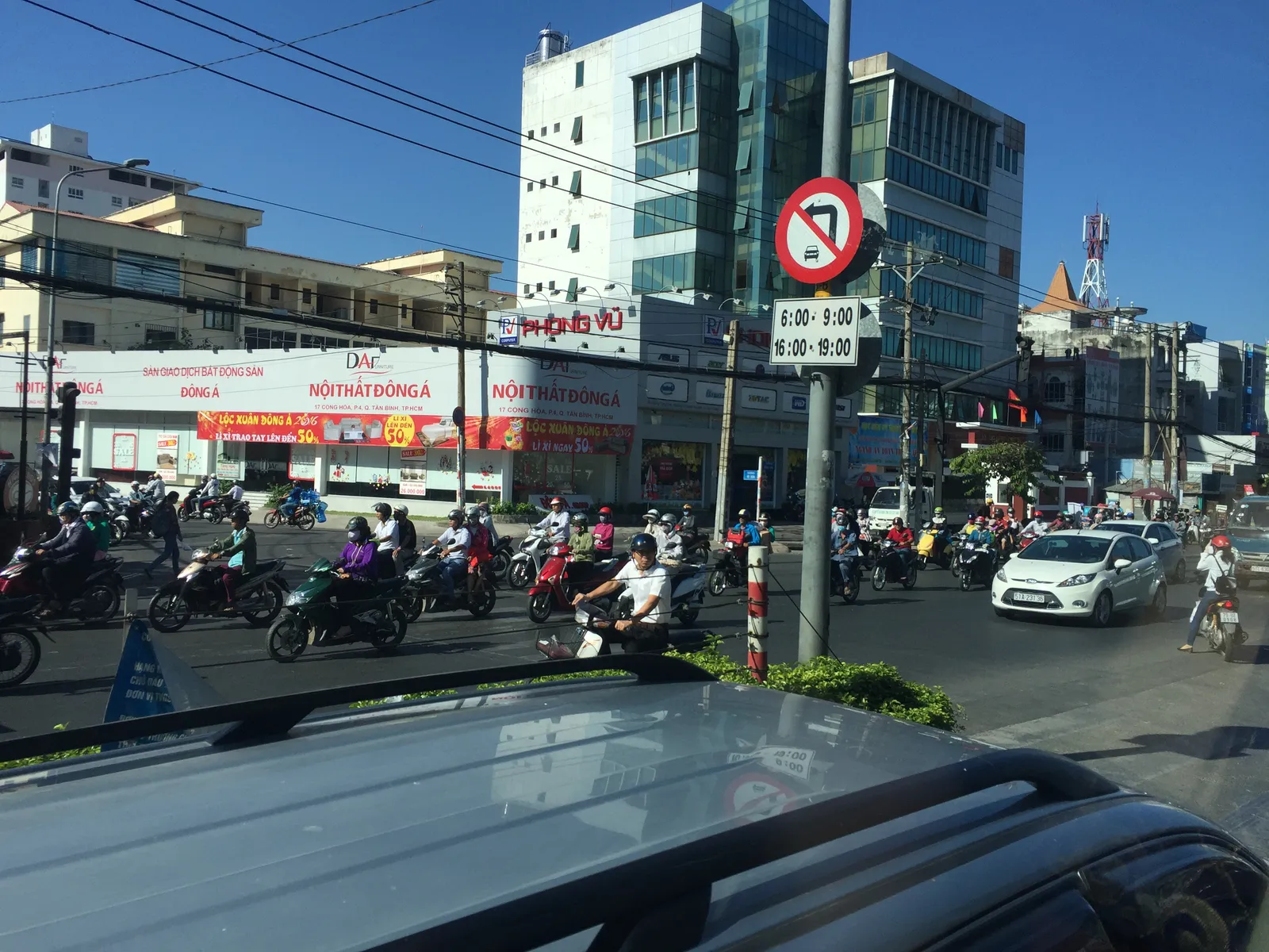 Street junction with motorbikes, a no-entry sign and glass office buildings