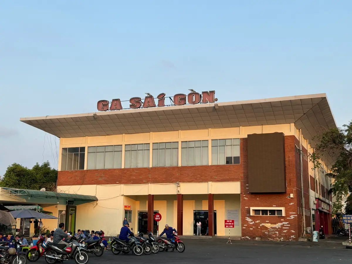 Orange-roofed station building with the Ga Sai Gon sign and motorbikes parked in front