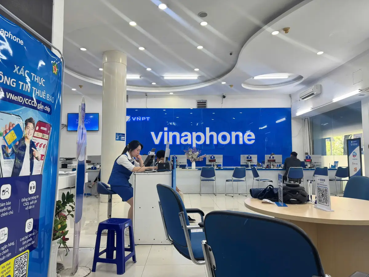 Inside the VinaPhone transaction point with blue desks, stools and a blue VinaPhone wall sign
