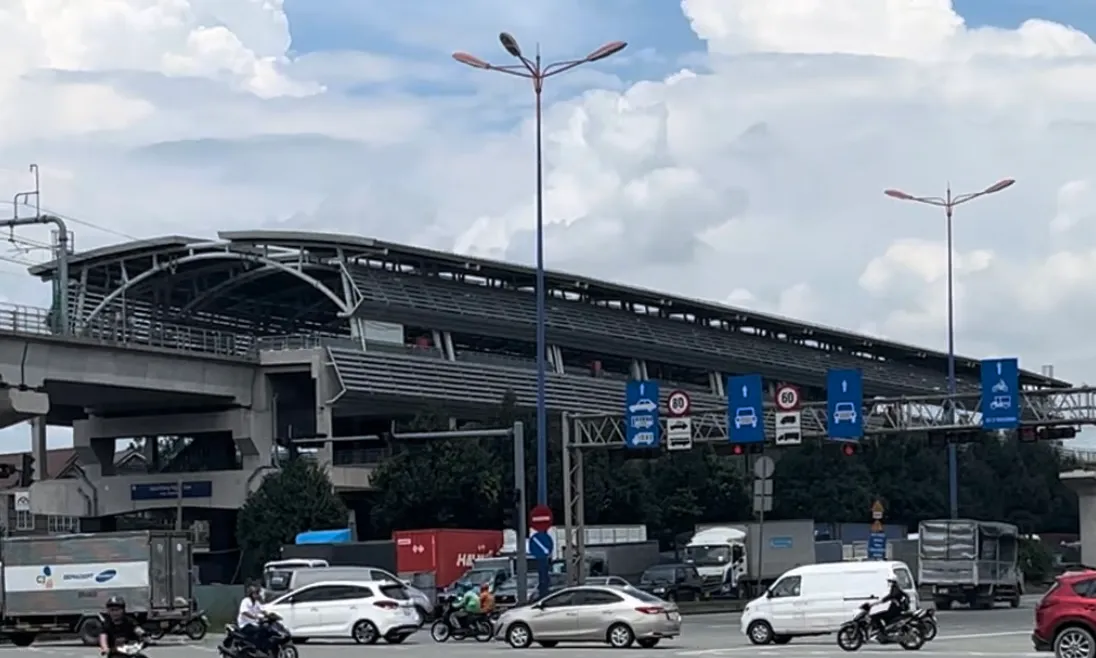 Steel-roofed elevated metro station above a busy road